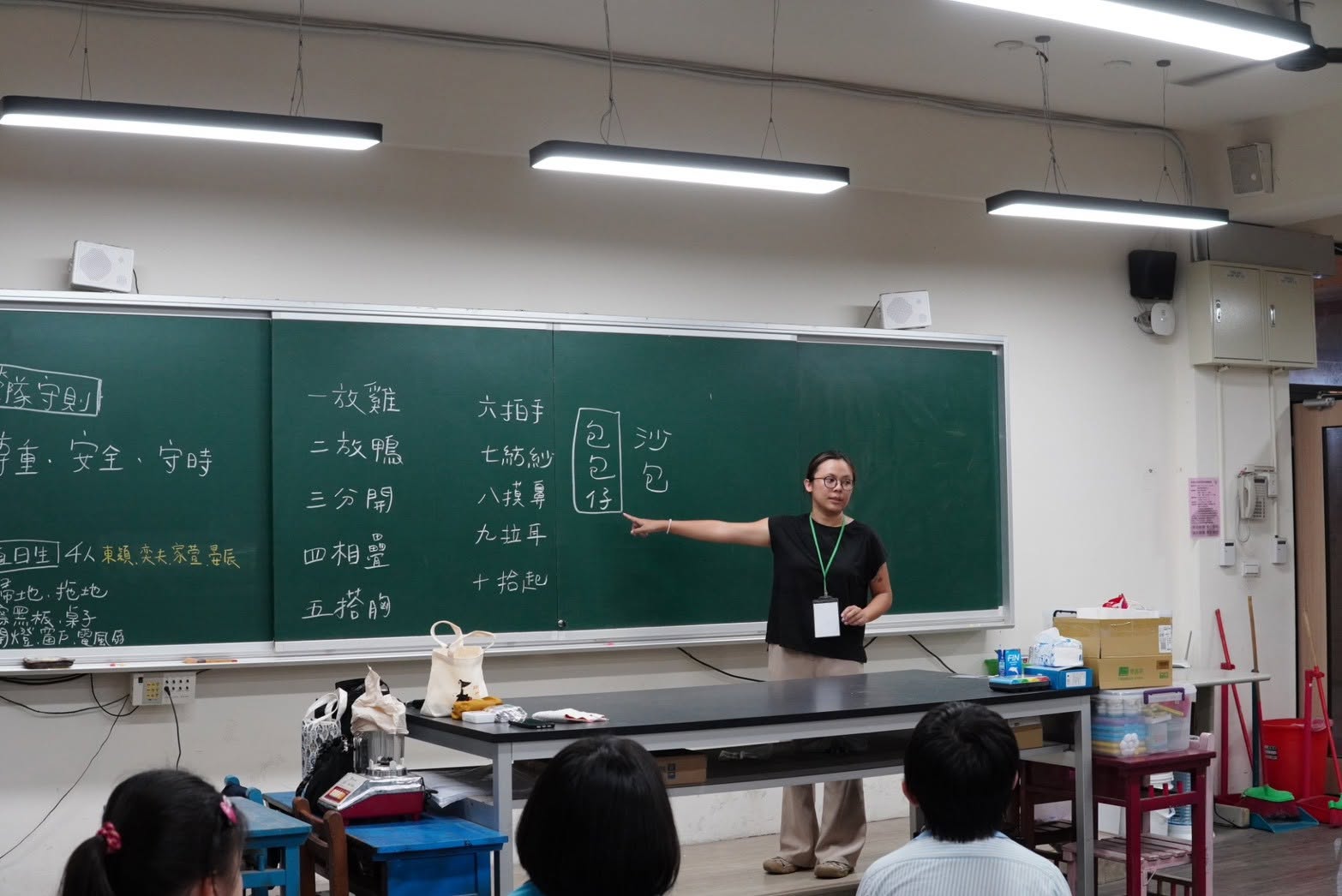 Teacher writing Taiwanese sandbag-game vocabulary on the blackboard