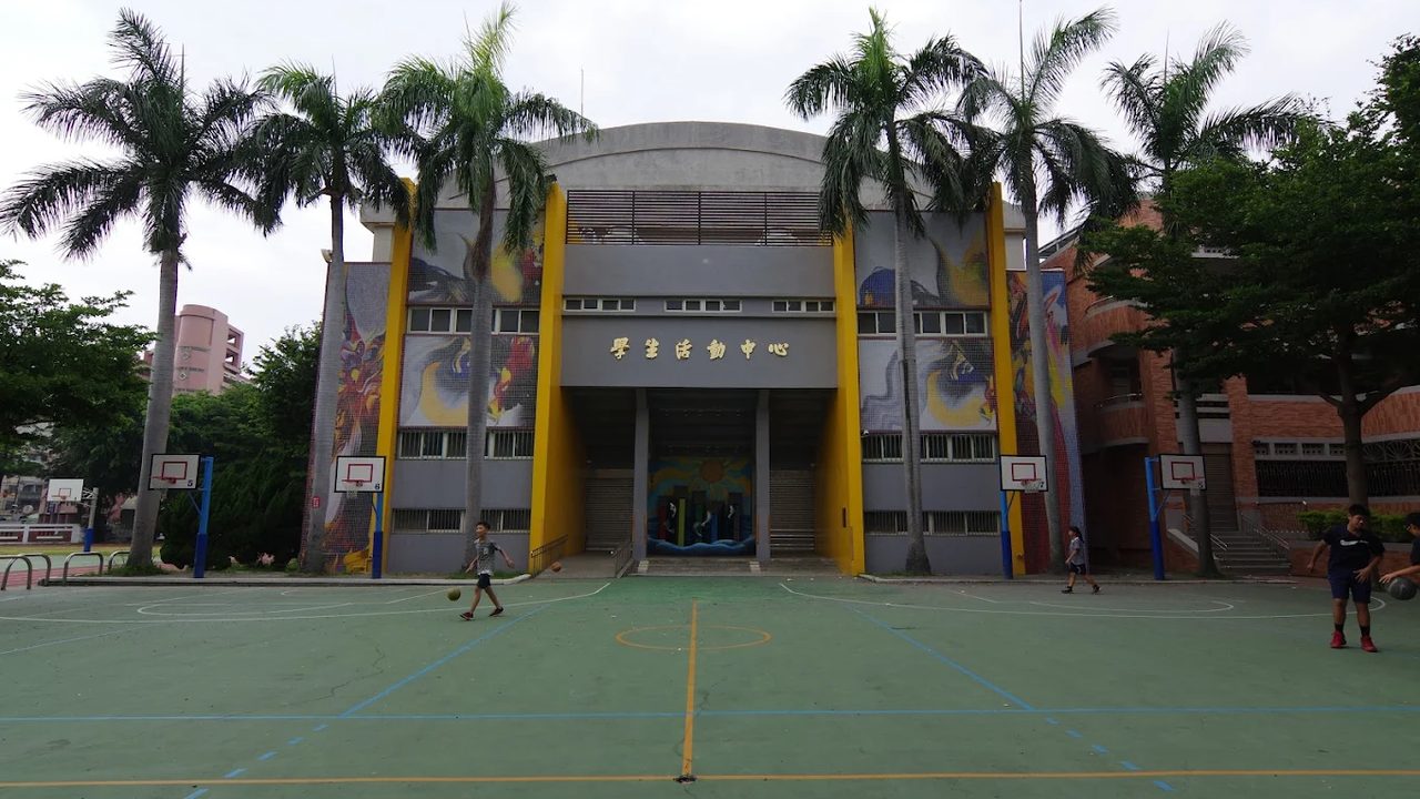 鹿港國小學生活動中心前，學生在球場上打球