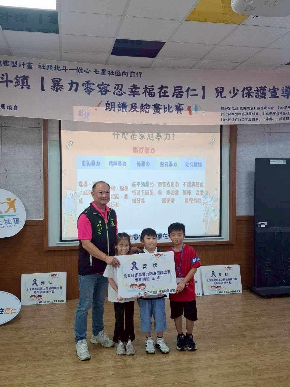 三位螺青學生手持朗讀比賽低年級組優選獎狀合影