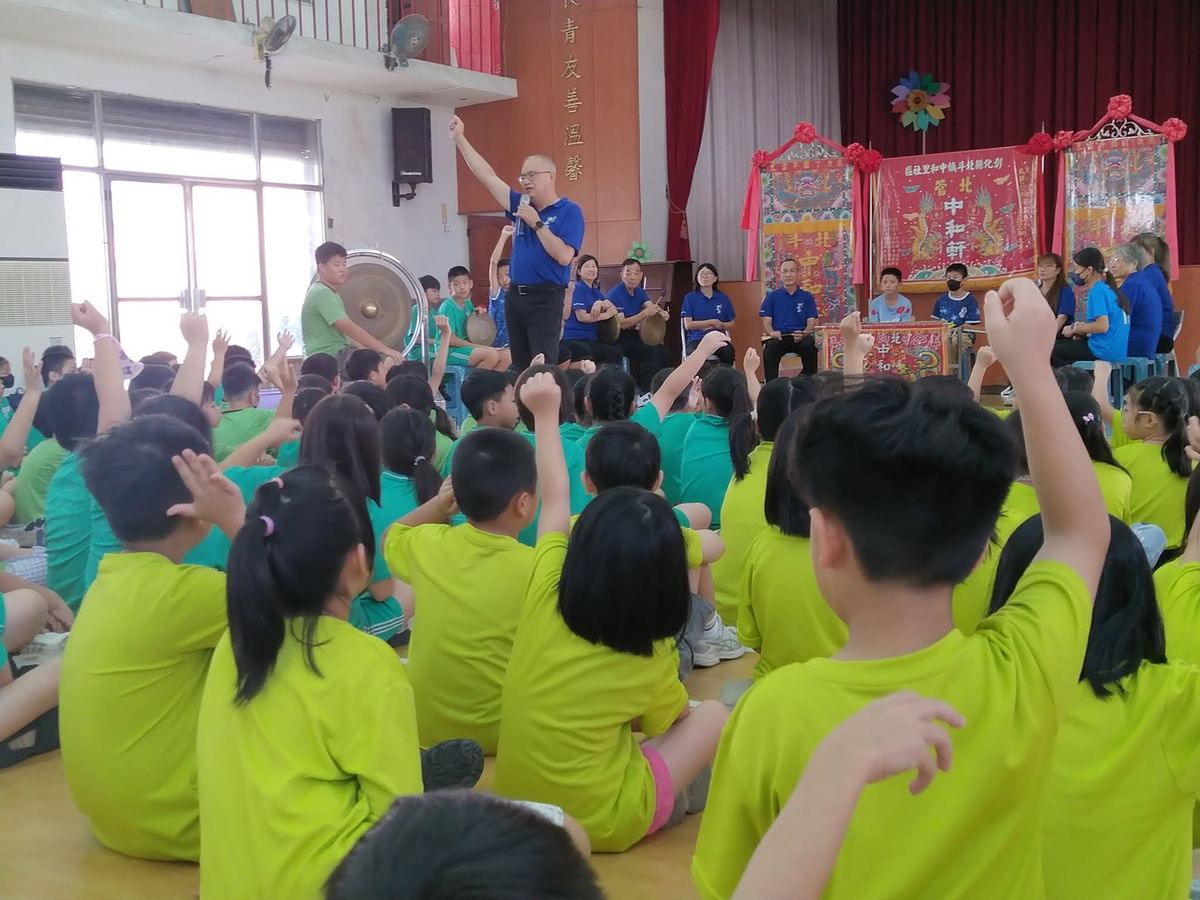 樂師敲鑼，學生舉手互動回應節奏