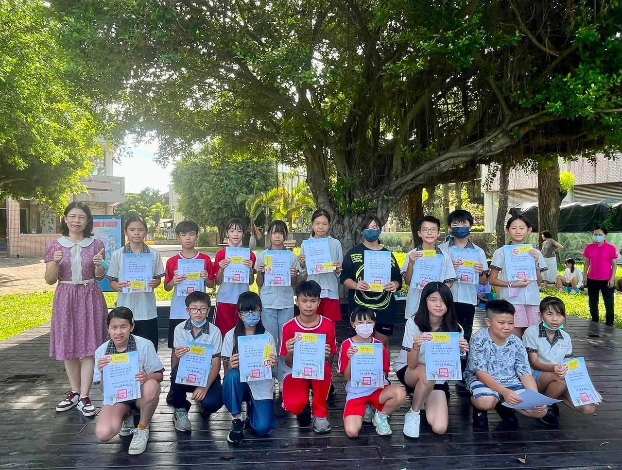 螺陽國小學生在大榕樹下手持獎狀合影