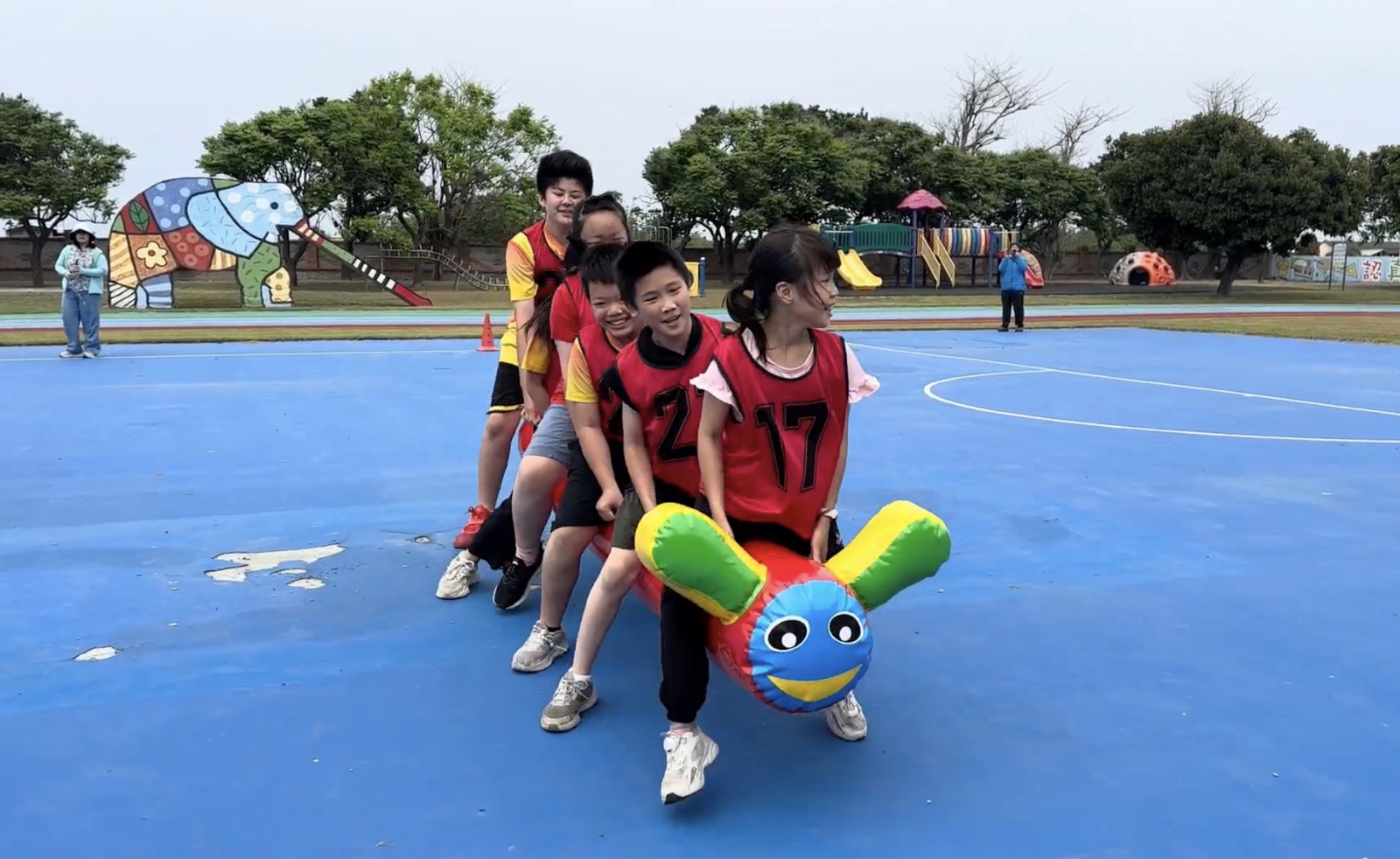Students playing an inflatable caterpillar relay game at Lushang's Fun Games
