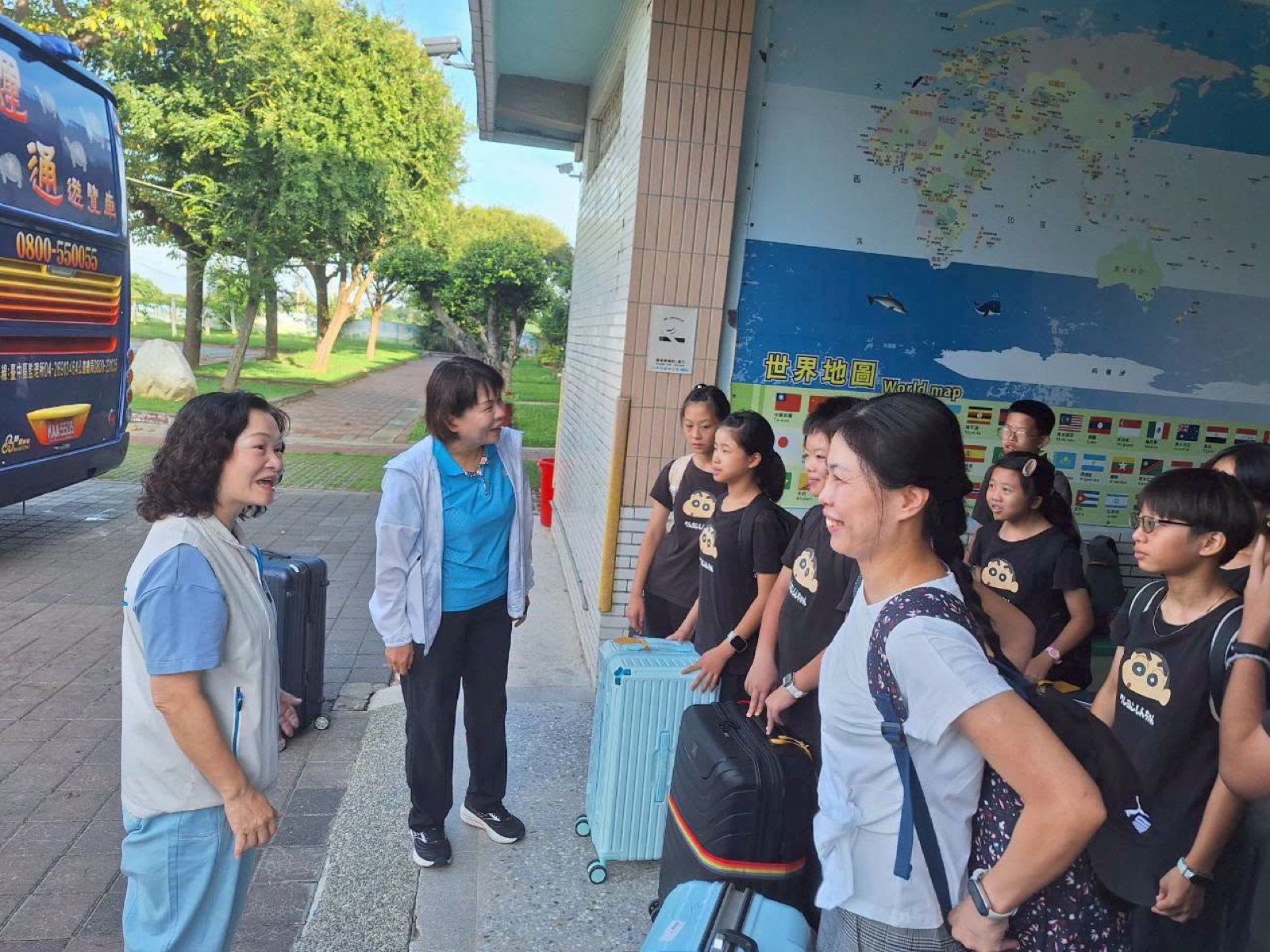 Students say goodbye in front of a world map at school