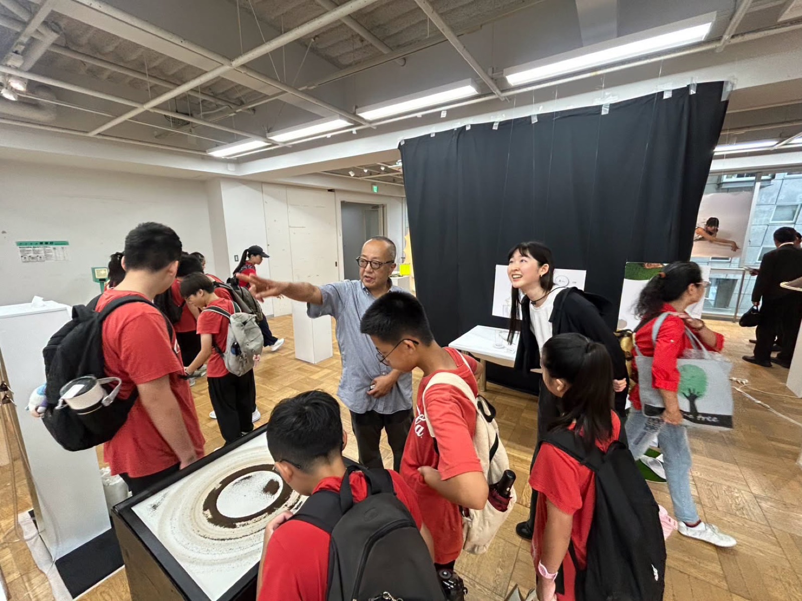 Students view a sand-art installation in the gallery