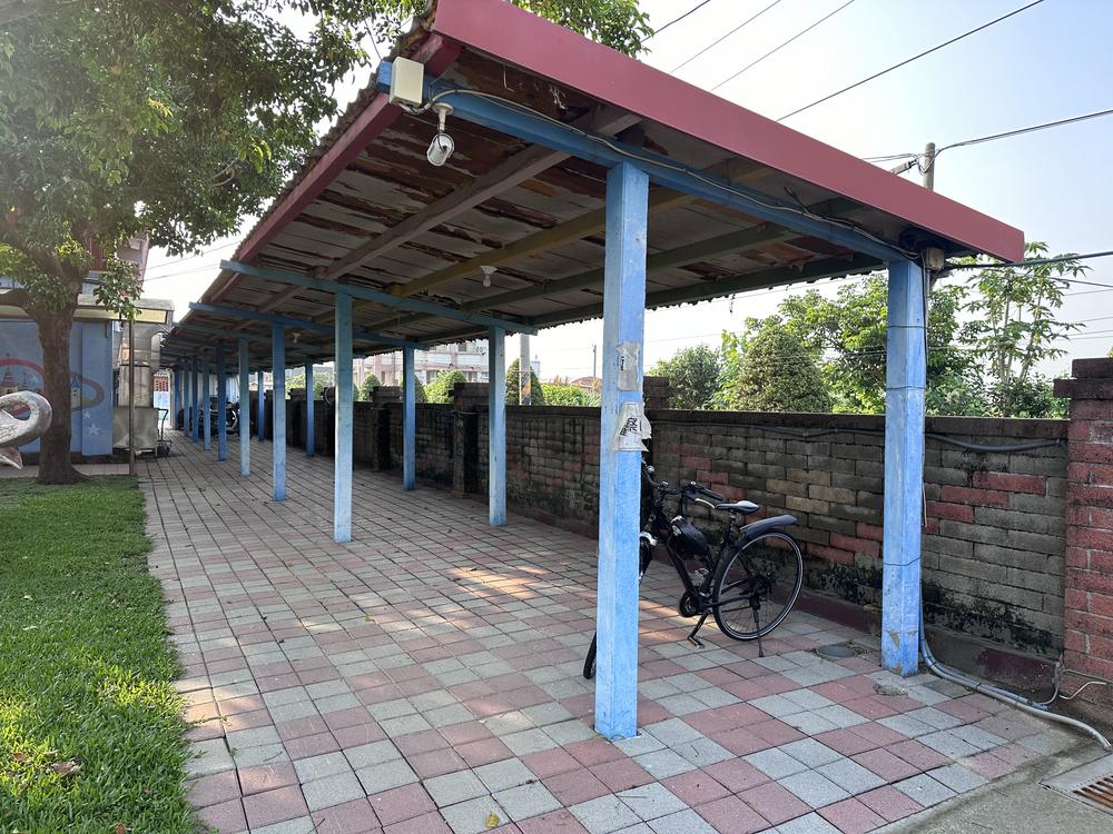 Blue-pillared bike shed with a red roof