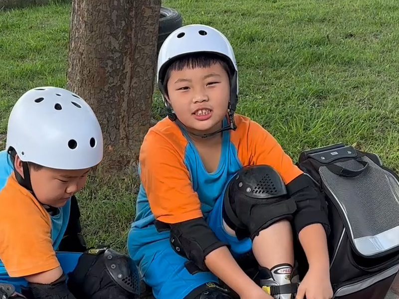 Two students wearing white helmets · 安全帽