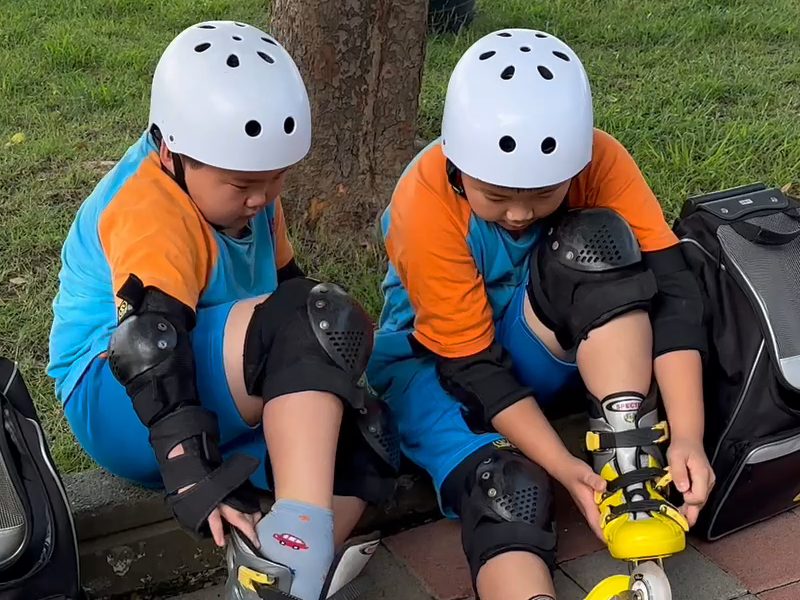 Two students with knee pads putting on their skates · 護膝
