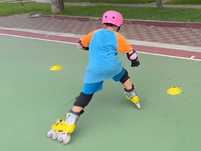 A student pushing off and gliding on one foot · 單腳滑行