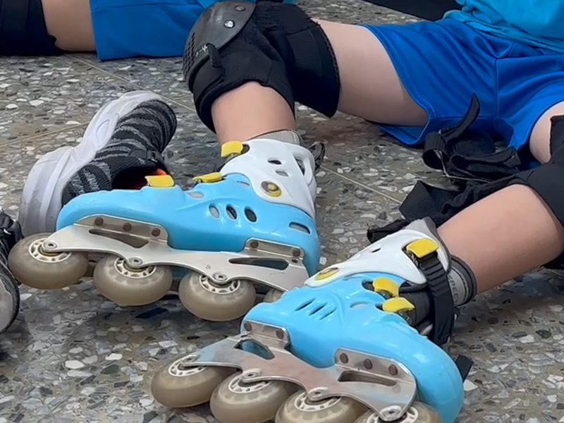 A pair of blue inline skates on the floor · 直排輪鞋