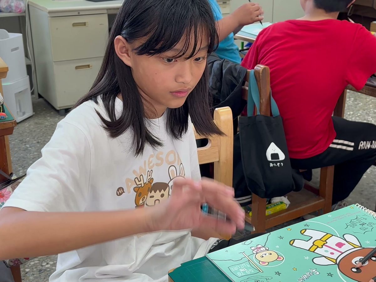 A student doing the rubber pencil trick · 學生練習「鉛筆變軟了」的視覺魔術
