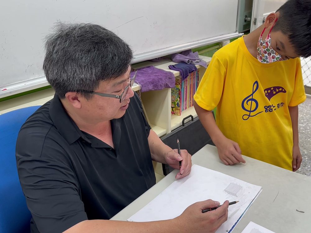 Mr. Chu helping a student with a sketch · 朱博揚老師指導學生素描