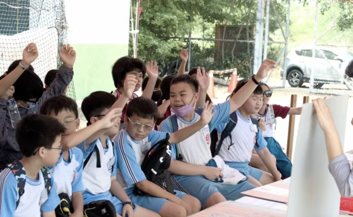 明正國小學生在戶外考古體驗活動中舉手熱烈參與