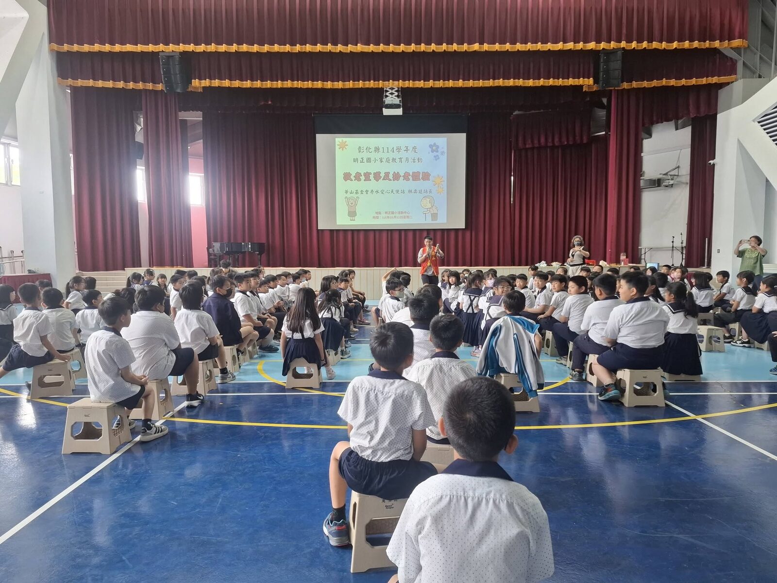 華山基金會志工向明正國小學生說明敬老體驗活動