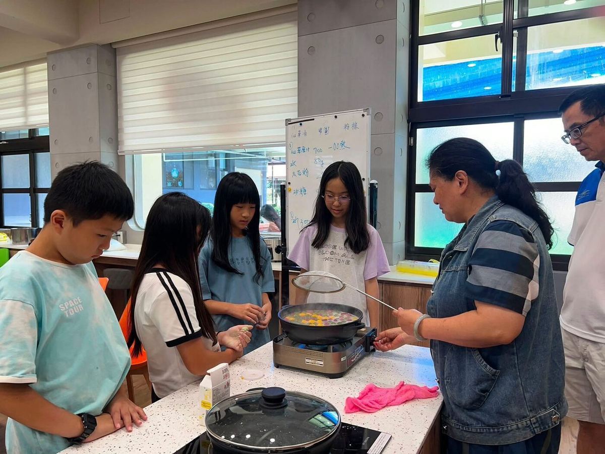 Students cooking with a helper