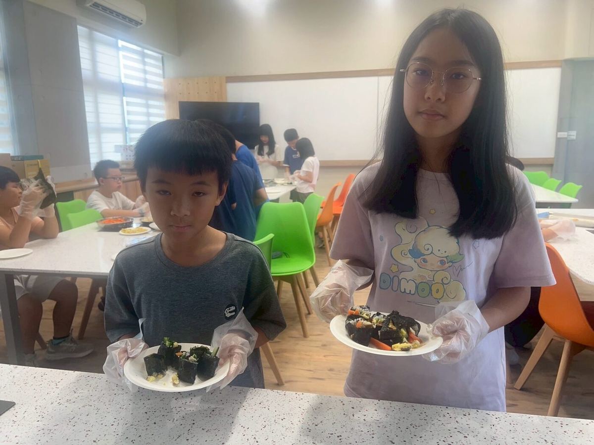 Students holding their finished dishes