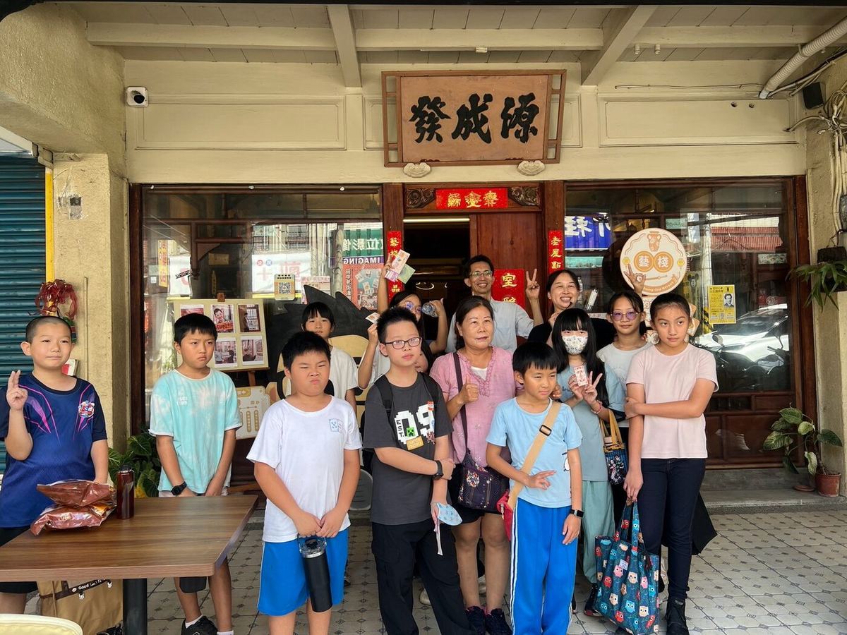 Students at the entrance of a historic old-street shop