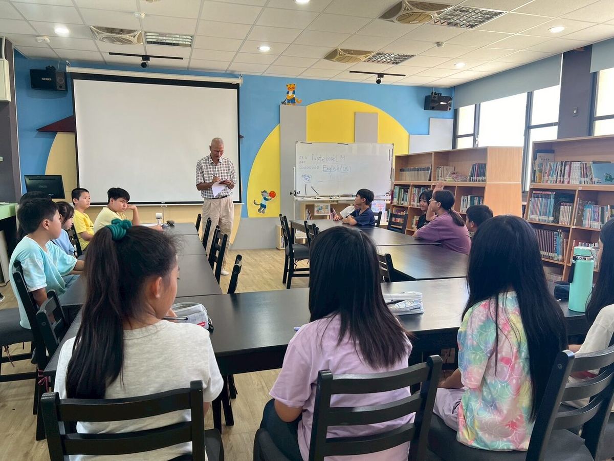 A student standing near the teacher during the lesson