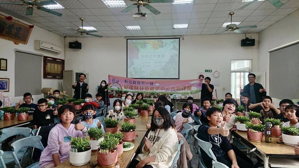 南鎮國小學生在教室裡，桌上擺滿一盆盆綠色盆栽 Nanjen students in a classroom with rows of green potted plants on the tables