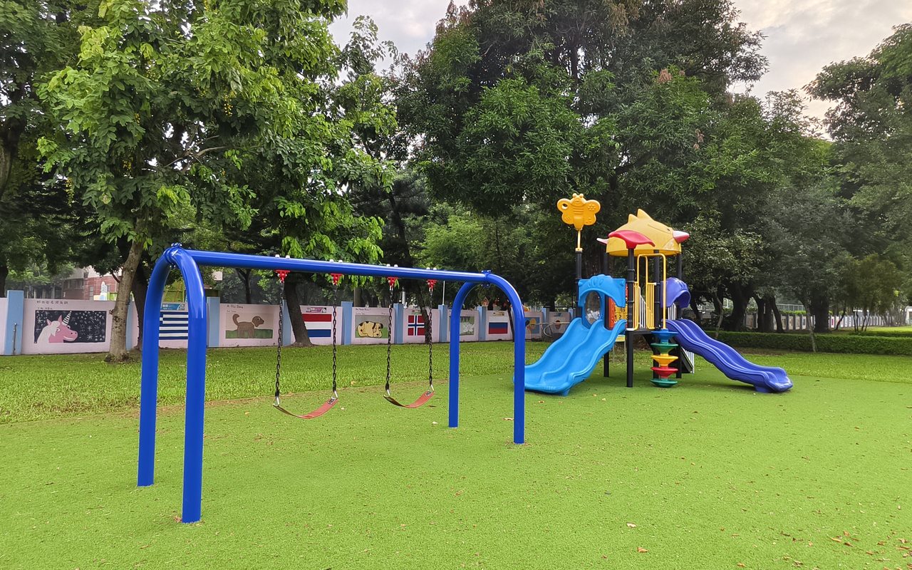 校園草地遊樂場——藍色鞦韆與彩色滑梯