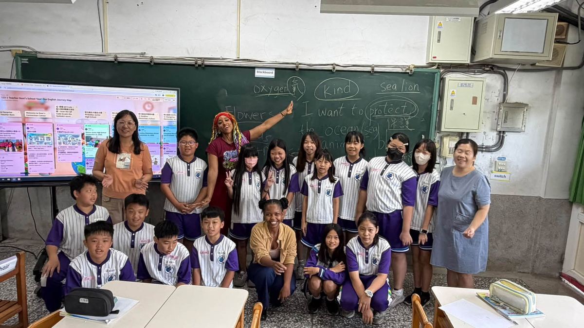 Dom Jones 與南鎮國小全班學生及老師在教室黑板前大合照 Dom Jones with a whole Nanzhen class and their teachers in front of the blackboard