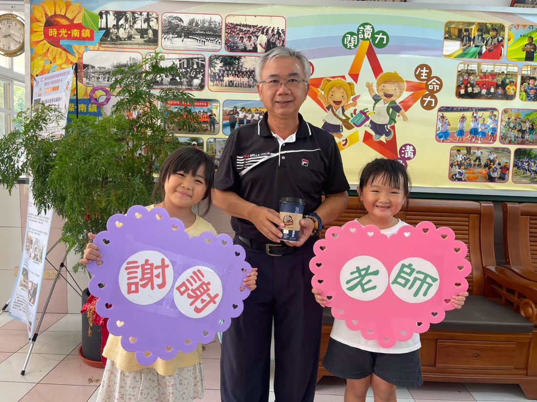 南鎮國小學生手持「謝謝老師」「讚」「棒」字牌與老師合影 · Nanzhen students hold "Thank you, teacher" signs beside their teacher