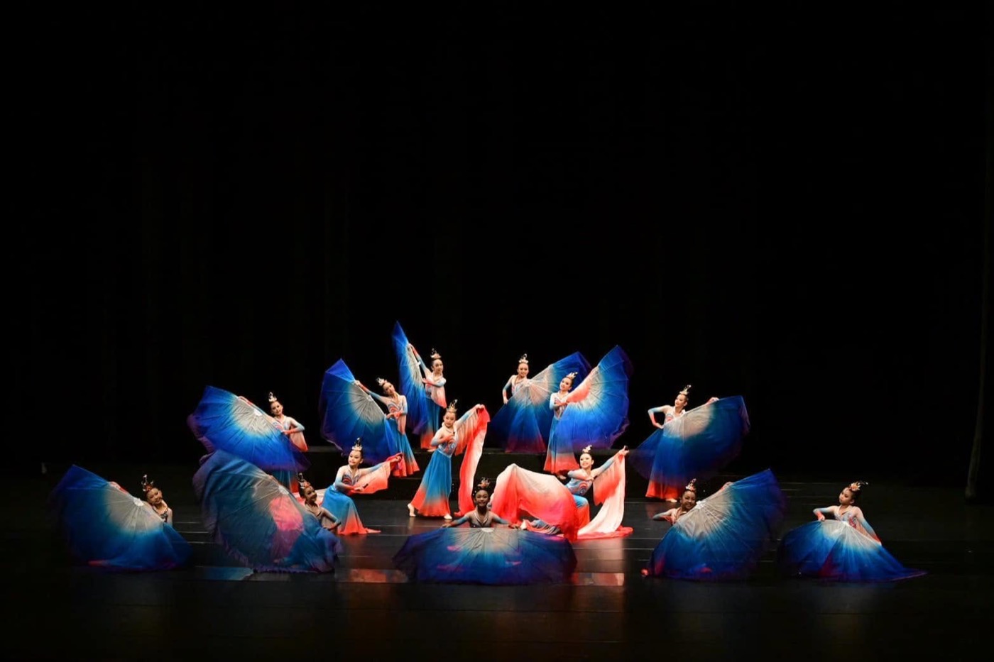 Pinghe's dance team performing with blue and red fan umbrellas on stage 平和舞蹈隊扇傘舞台表演