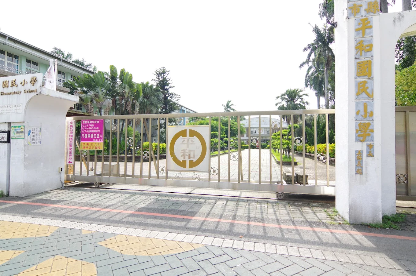 Pinghe's front gate with the school emblem and name 平和國小校門與校徽