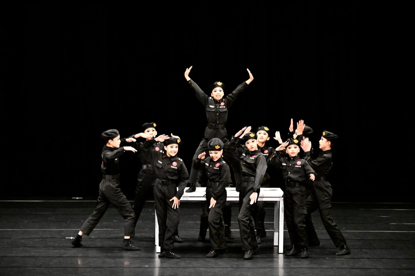 Pinghe students performing a modern dance in uniform costumes on stage 平和學生制服風現代舞展演