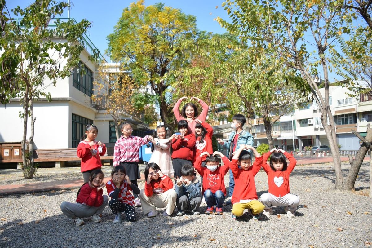 Pinghe students and a teacher making heart shapes with their hands outdoors 平和師生在戶外比愛心合影