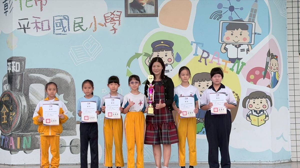 Principal Wang Li-hui with award-winning students holding a trophy 王麗惠校長與獲獎學生及獎盃合影