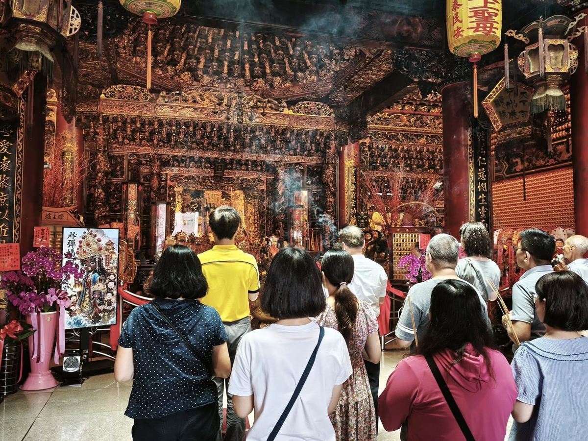 眾人於合興宮主殿前虔誠祈福 The group praying quietly before the temple's main altar