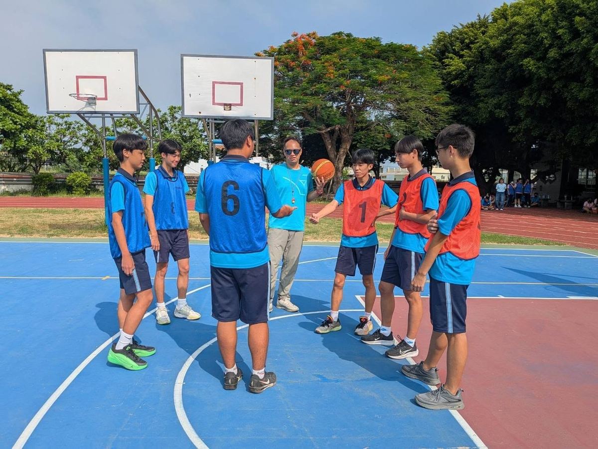 裁判為兩隊球員拋球開賽 A teacher referee tosses the ball for the opening tip-off