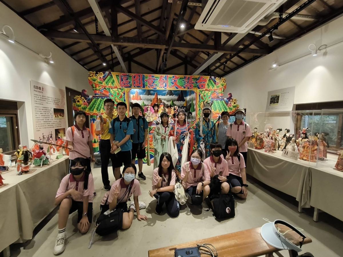學生與歌仔戲戲偶及戲服合影 Students posing with opera puppets and costumes
