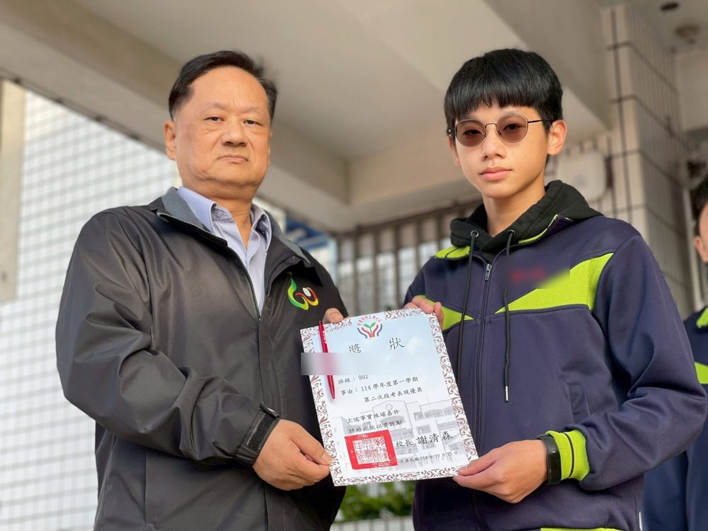 Principal Hsieh Ching-sen presenting a certificate to a student 謝清森校長頒發獎狀給學生