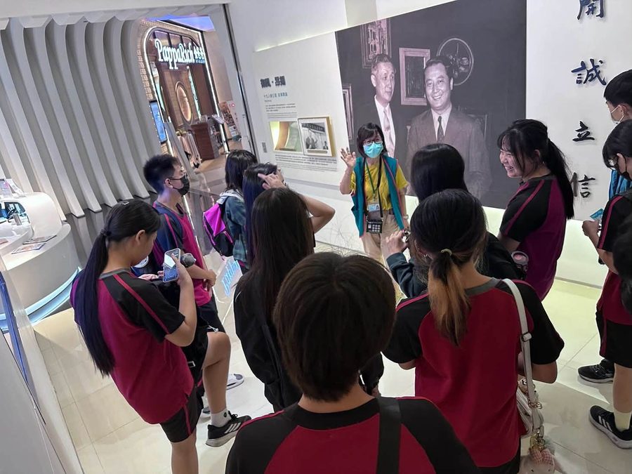導覽員在一幅大型黑白照片前，為埔中與羅厝國小的學生解說 A guide explaining an exhibit to Pusin and Luocuo students in front of a large black-and-white photo