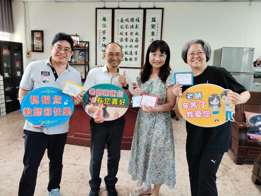 走訪學區國小時，四位師長在校長室手拿「祝福您教師節快樂」「老師辛苦了 我愛您」牌子與學生手寫的敬師卡片 Four educators at a district elementary school holding Teacher's Day signs and students' handwritten cards