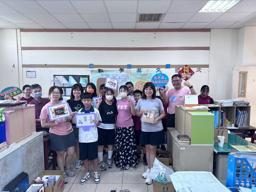 同學和老師們在辦公室裡合照，手拿「Thank You」「師恩日日念」敬師牌與紓壓小禮物 Students and teachers posing in a teachers' office with thank-you signs and small gift bags