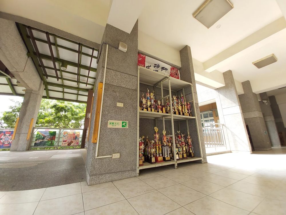 埔心國中走廊上兩座擺滿獎盃的層架 Two shelves crowded with trophies along a Pusin corridor