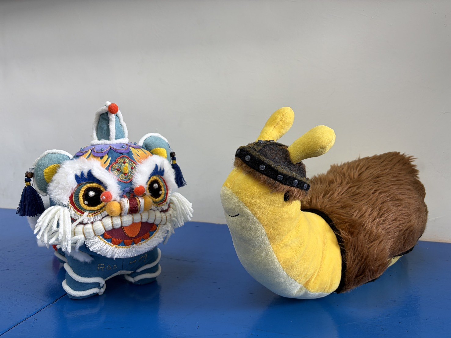Raoming's lion dance mascot beside Windship Middle School's banana slug mascot · 饒明舞獅吉祥物與美國 Windship 香蕉蛞蝓吉祥物