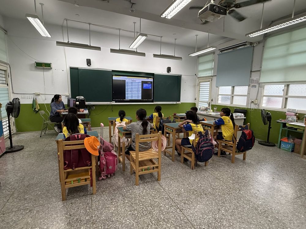 水尾國小學生課後坐在座位上，一起看大螢幕上的補充教材