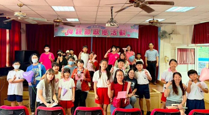 Mother's Day group photo on stage under the banner · 母親節活動舞台合影
