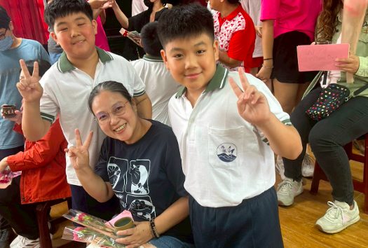 Two students pose with their mother — peace signs and smiles · 兩位學生與媽媽合影