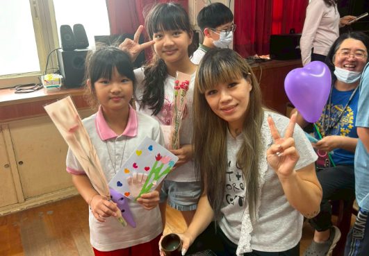 Students proudly holding handmade Mother's Day cards, carnations, and balloons · 學生捧著手作卡片、康乃馨與氣球