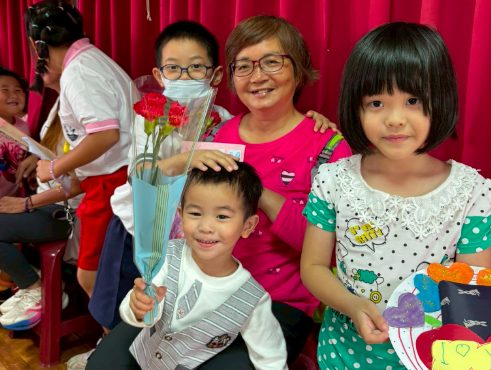 A Sigang mother with two children and a carnation bouquet · 母親節 媽媽 孩子 康乃馨