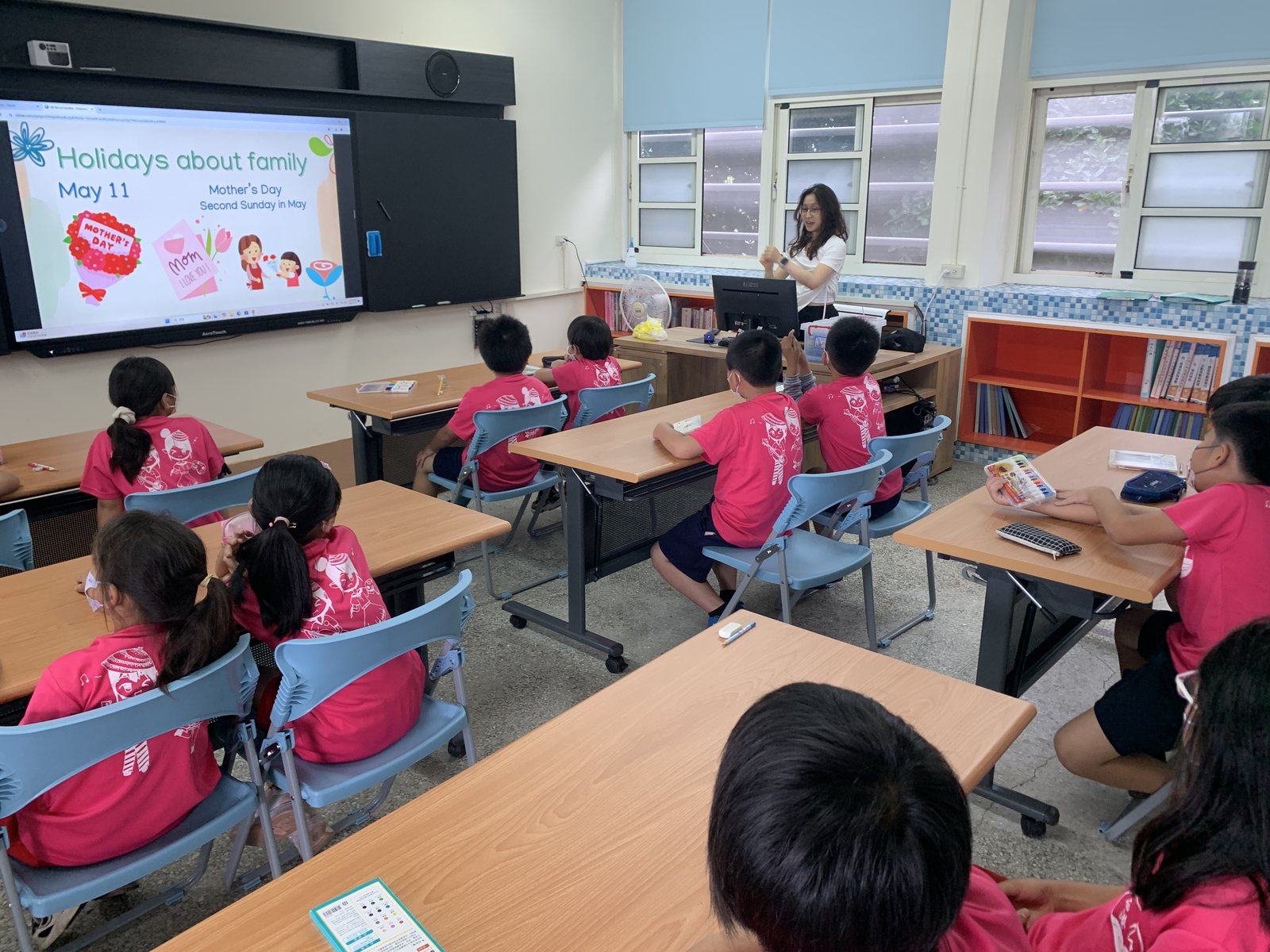 ETA foreign teacher leading a lesson on the campus touch-screen · ETA 巡迴外師使用觸控大電視進行教學