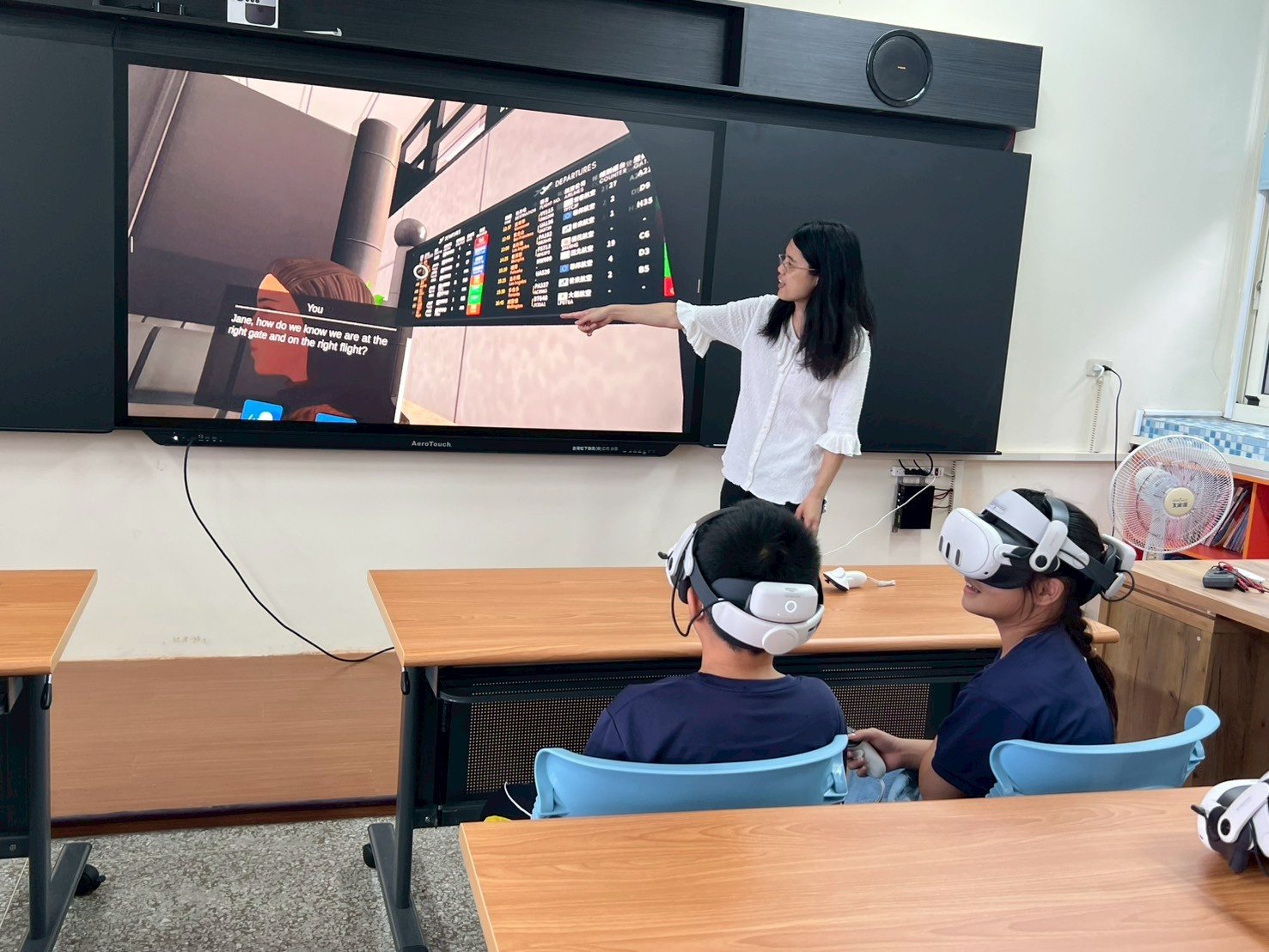 International English Village — teachers guide students to converse using VR helmets · 國際英語村 教師引導學生使用 VR 虛擬互動頭盔進行對話