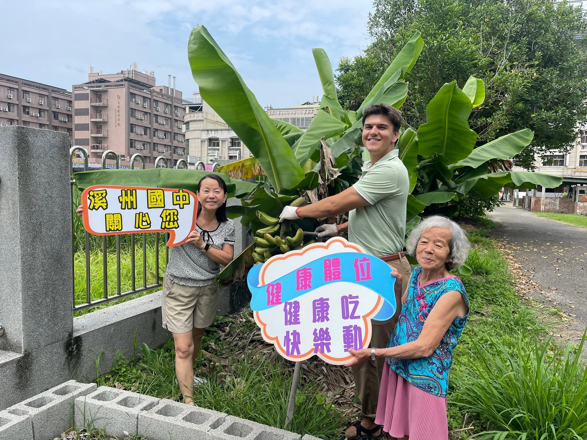 外師與溪州國中同仁在香蕉樹前與社區長輩合影
