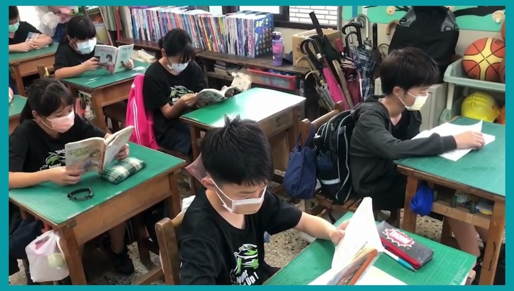 Sijhou students reading silently in their classroom, with a wall of picture books behind them