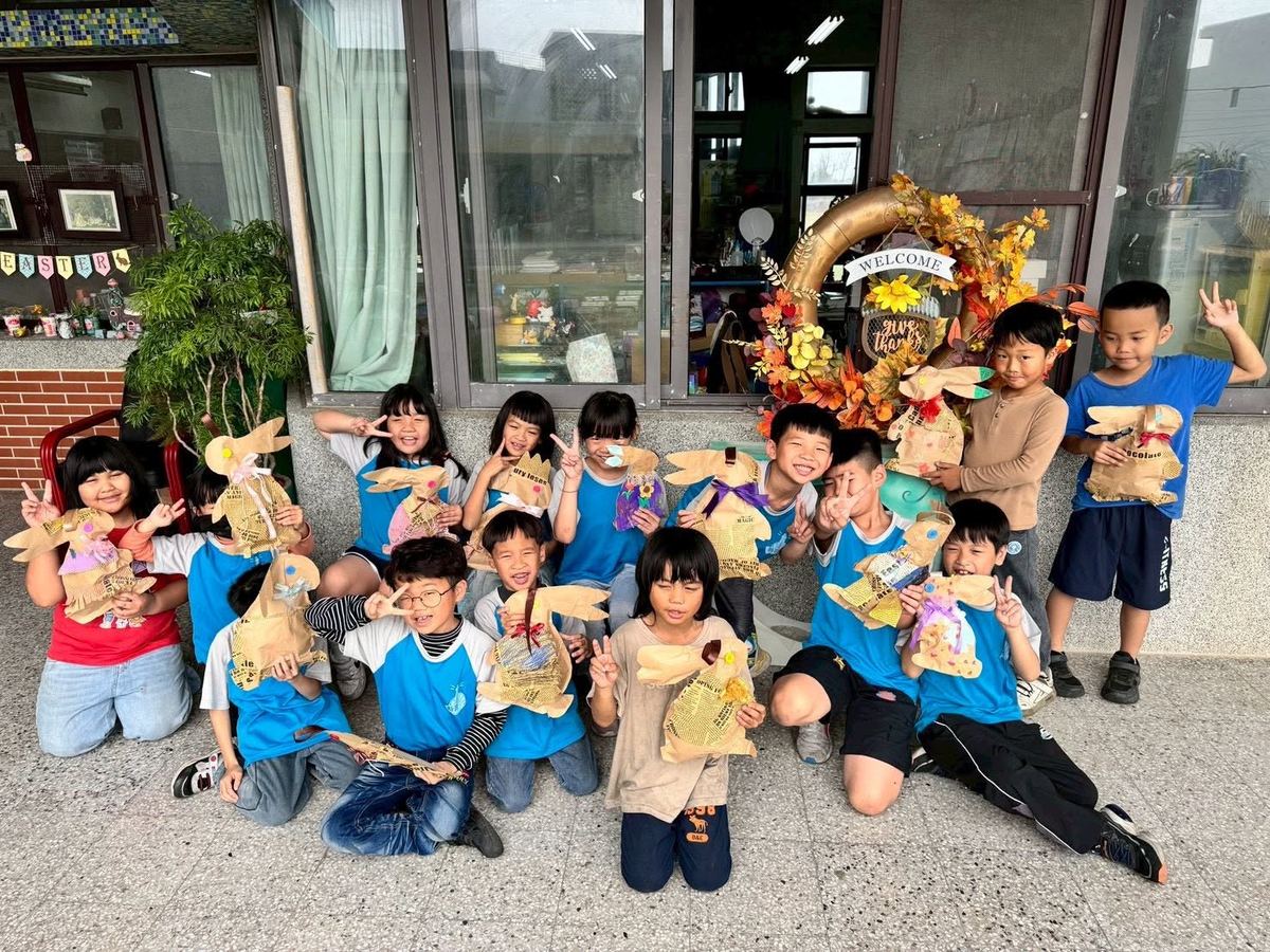 Sinbao students posing with handmade paper bunny crafts 新寶學生與手作兔子勞作合影