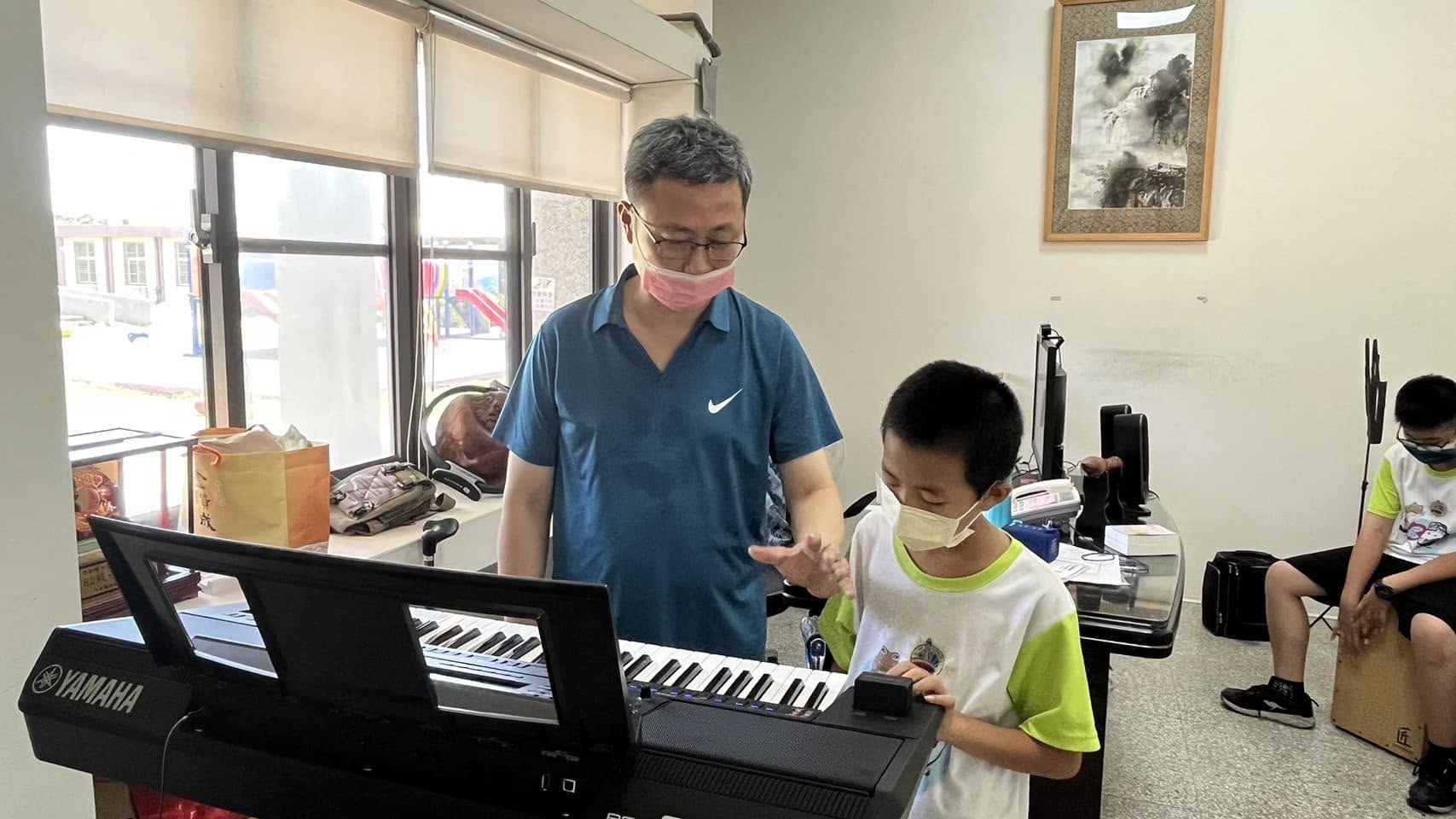 Principal Fang teaching a student to play the keyboard · 方順陽校長教學生彈電子琴